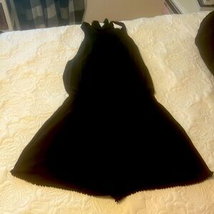 Black romper with a tie at the back of the neck.